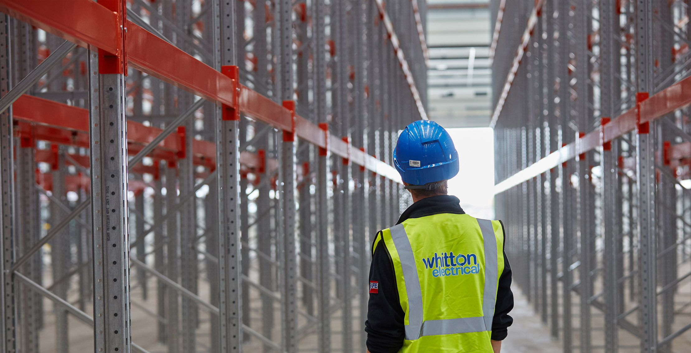 A Whitton Electrical engineer inspecting lighting between racking